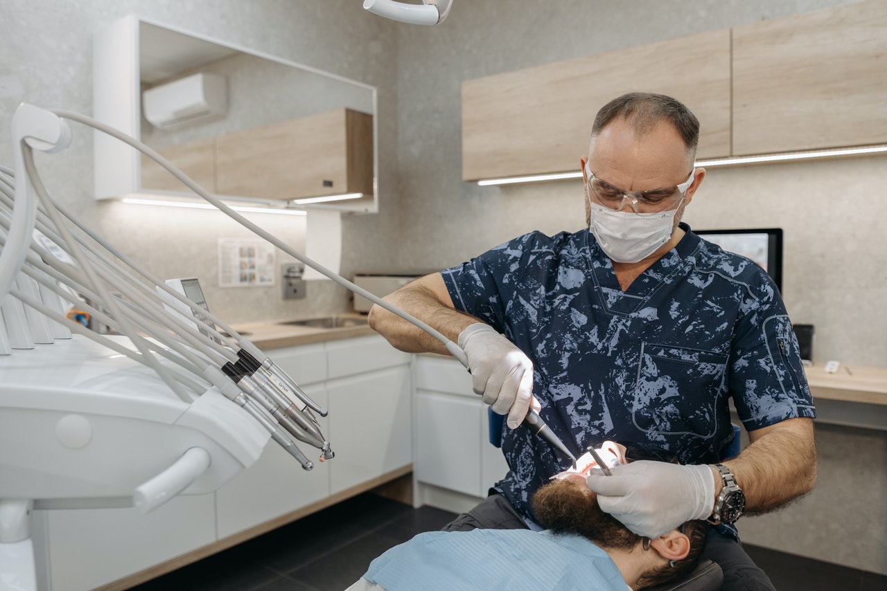 Dentist does the teeth examination of his patient