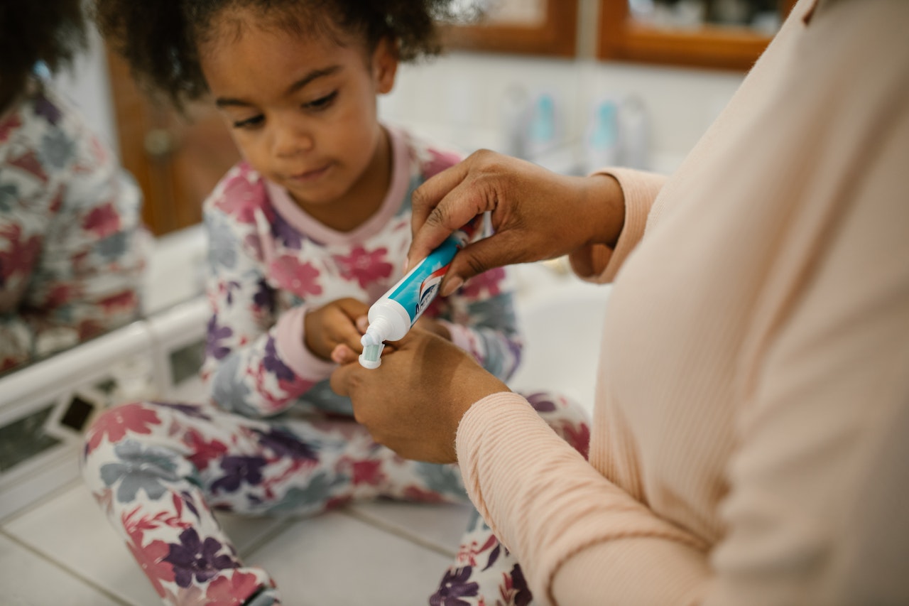 Toddler is using hers toddler training toothpaste